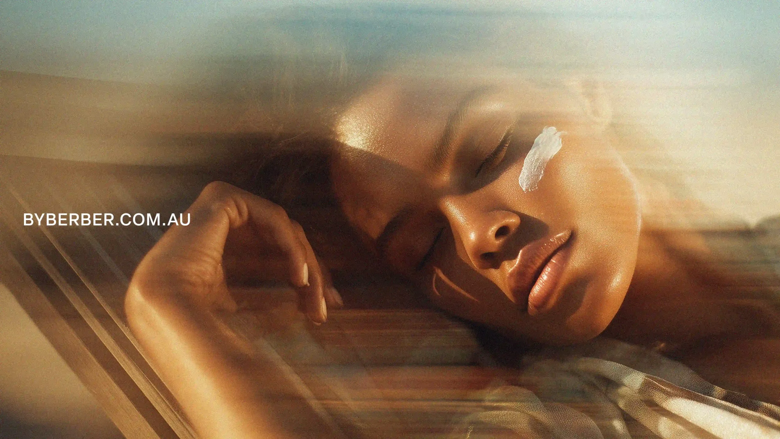 Woman with sunscreen on face, glowing skin, "BYBERBER.COM.AU" cta, sunscreen, cosmetic brand.