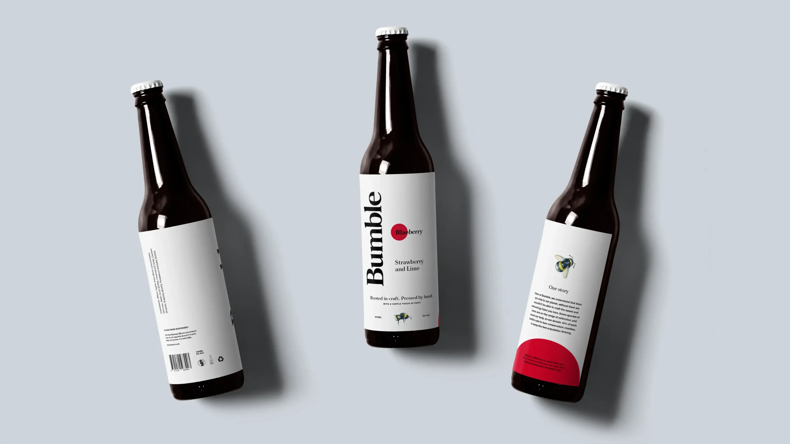 Three cider bottles lying down with Blaeberry and Strawberry and Lime labels arranged on a light grey background.