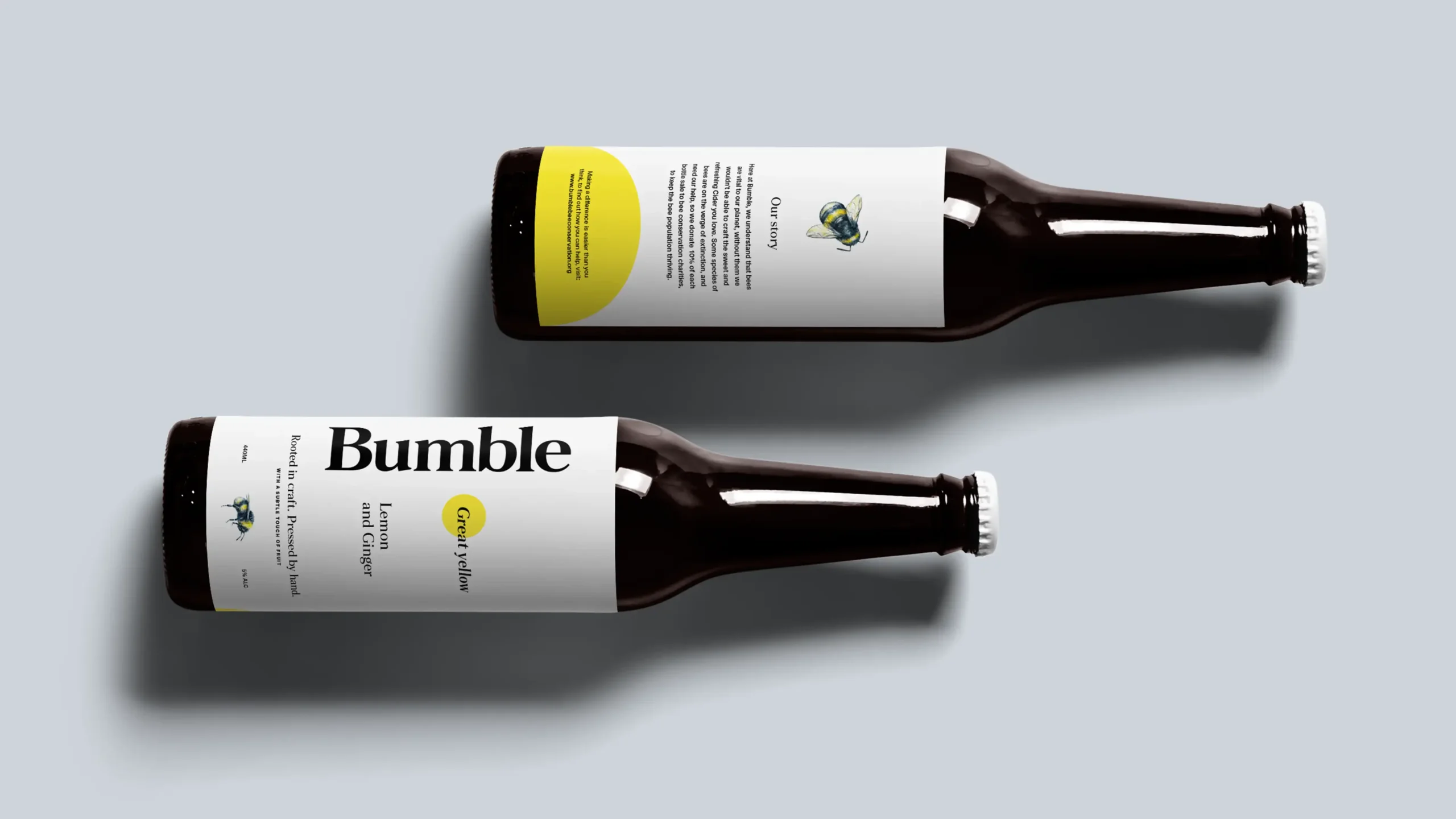 Two cider bottles with Lemon and Ginger labels lying on a light grey background.