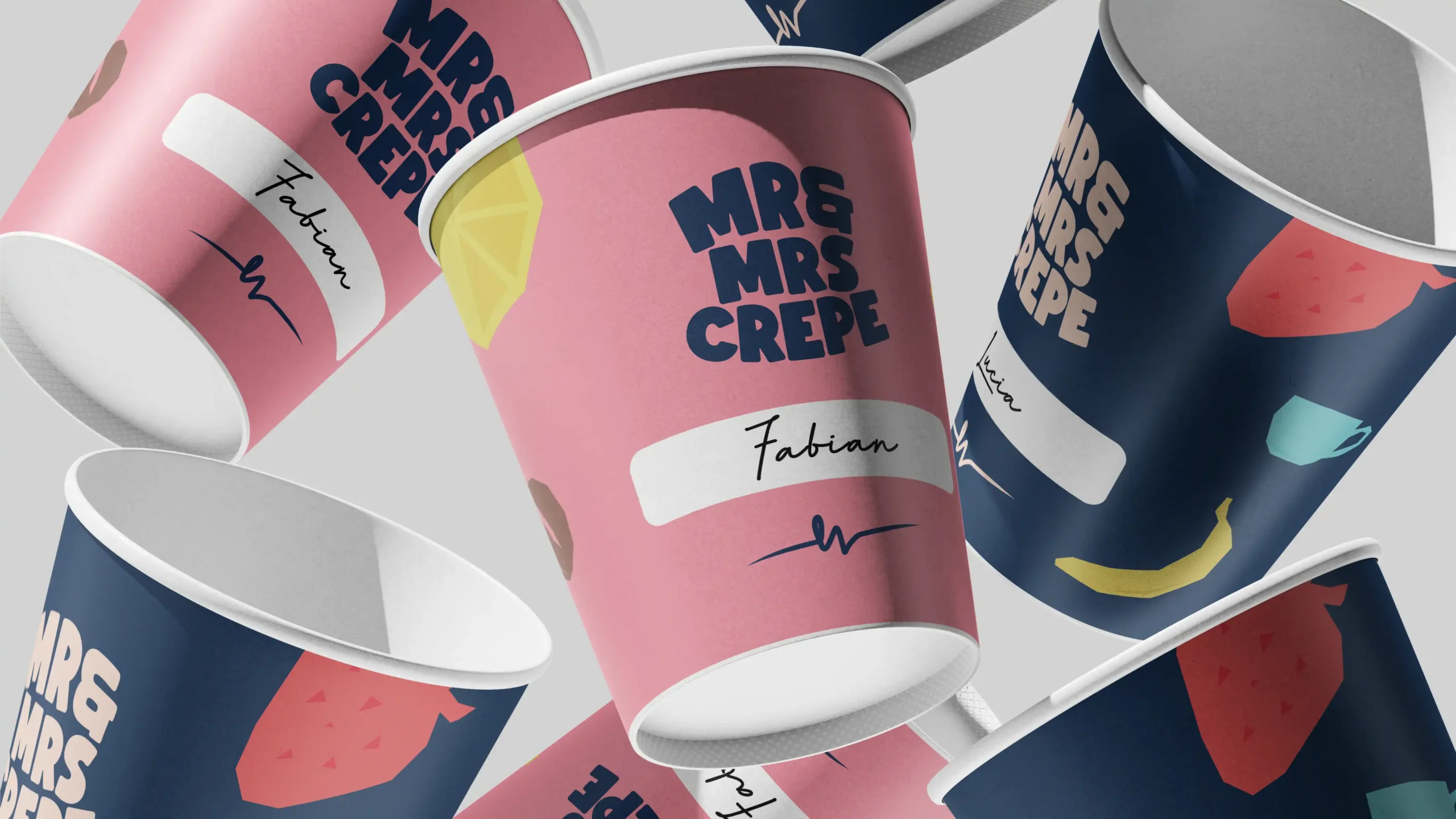 MrandMrsCrepe_Showcase_006 Scattered Mr & Mrs Crepe paper cups in pink and blue, with brand illustrations and a "Fabian" signature.